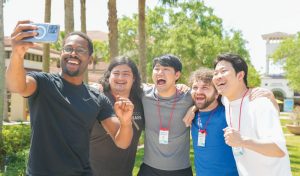 A group of SGI-USA young men's division members taking a selfie together at a conference.